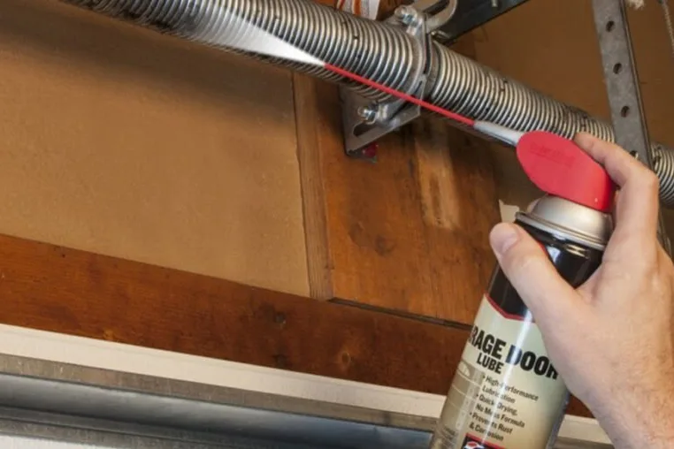 Lubricating a garage door torsion spring during annual maintenance